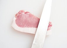 脂身側を手前に置き、包丁の平でトントンと軽く叩いて、肉全体をほぐす。