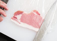 肉にラップをかけ、包丁の平（または小鍋の底など）で叩いてのばす。薄くのびた肉は、両手で寄せて成型し、元の大きさに戻す。