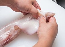 エンペラと胴がつながっている部分に指を入れ、エンペラを引っ張り胴から剥がす。