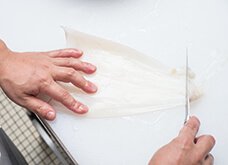 包丁を垂直に立て、胴の内部の表面を軽くけずり落としてきれいにする。