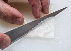 【いかの格子切り】等間隔に、斜めに包丁を入れる。半回転させて同様に切るが、斜めに入れた刃を最後におこすようにし、切る面積を多くする。