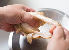 貝柱とひもの間に指を入れ、ひもを貝柱から取り外す。