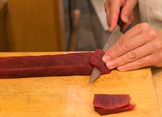 左手を柵の切り口の上に添える。包丁は根元から始まり包丁の全体を使うように滑らせ、斜めに、なるべく一回で切りつける。