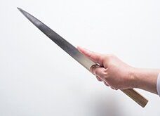【指差し】正確に繊細なものを切るとき、人差し指を支えにする。柄元を握る3 本指は固定。人差し指包丁の峰に置く。親指は包丁の刃元を支える。