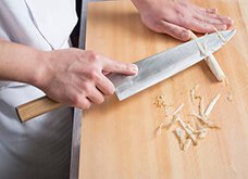 【例：ささがき】刃を外側に向けるときは、人差し指を刃元の腹にたてて固定し、バランスをとると良い。姿勢はまな板に対して斜め45度。