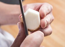 【例：皮をむく】かたい皮をむくときは、包丁を持つ手の親指を使う。皮をたぐり切り進め、切り取る厚みのバランスもとる。