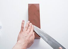 斜め上下に滑らせて動かし、まず包丁の刃先を研ぐ。
