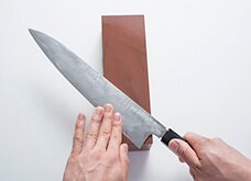 【表面】ひっくり返し、今度は反対の、表面へ。刃元から研ぎ石の上におき、支える手の指で刃元の腹を押さえる。